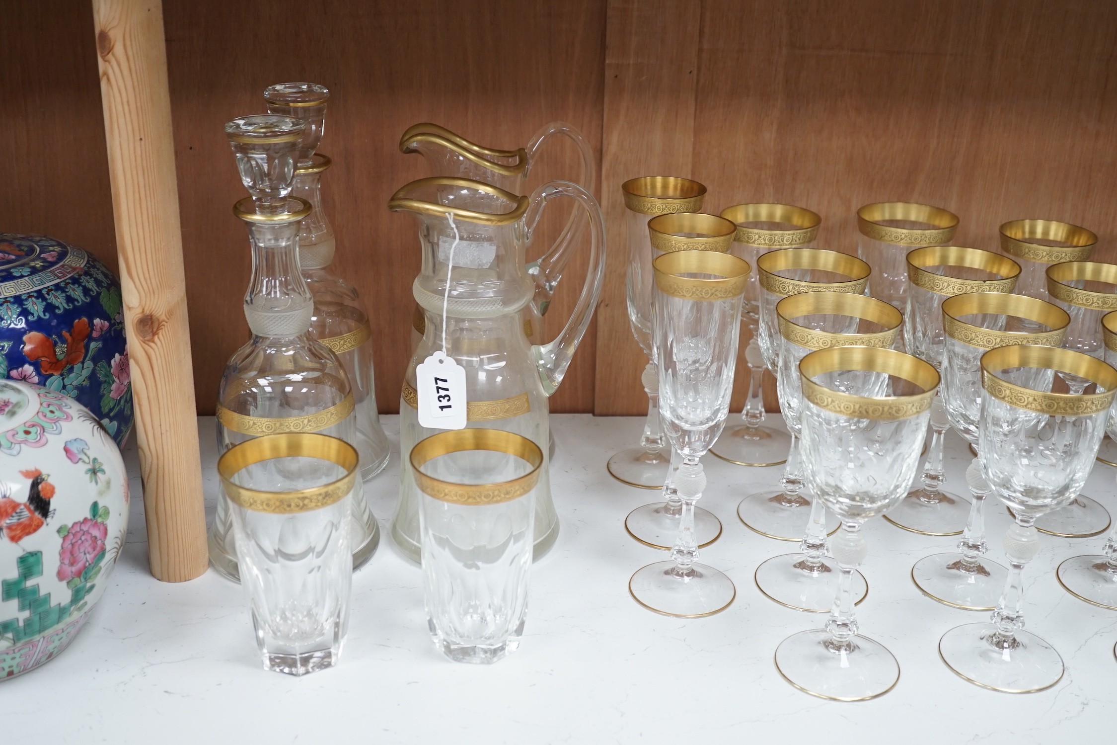 A Harrods retailed parcel gilt and cut and moulded suite of drinking glasses, two decanters and two carafes